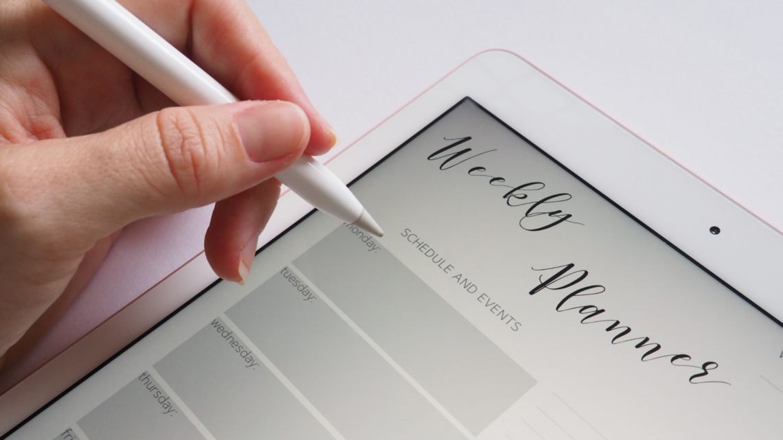 woman organising weekly planner on ipad