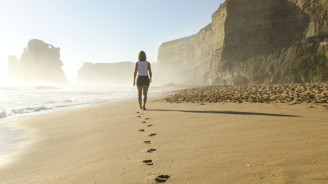 woman walking barefoot at the beach