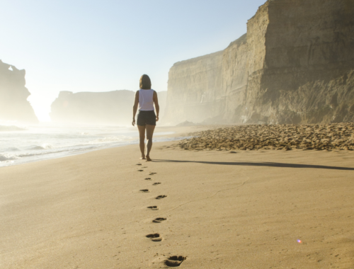 woman walking barefoot at the beach